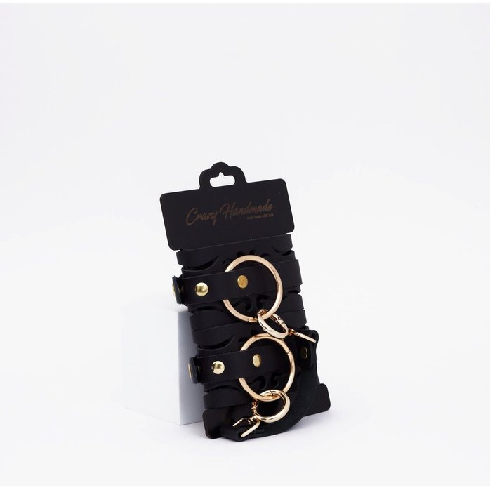 Черные кожаные наручники с золотистой фурнитурой. Фотография 3.