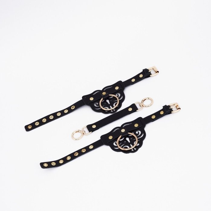 Черные кожаные оковы с резными узорами и клепками. Фотография 3.